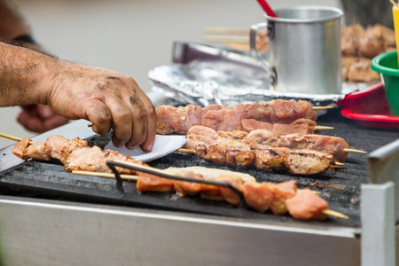 close up of a local mans hands grilling meat outdoorsの写真素材