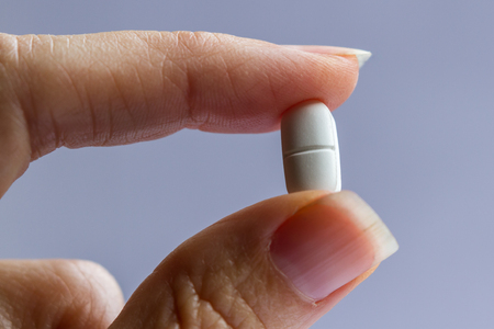 close up of fingers holding an opioid pain relieverの写真素材