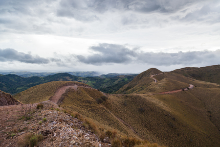 hiking path across the tops of a ridge with dries grass blowing in the wing in Costa Ricaの写真素材
