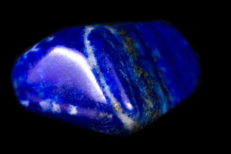 Close up of a beautiful blue piece of lapis lazuli isolated on a black background