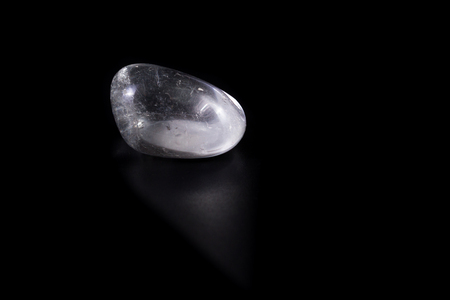 Close up of a polished piece of clear quartz isolated on a black backgroundの写真素材