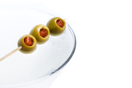 pimento stuffed olives on a bamboo skewer garnishing a dirty vodka martiniの写真素材