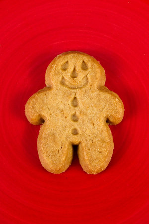close up of a ginger bread man cookie on a red plate