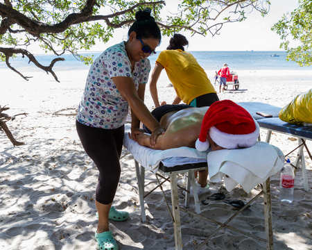 Playa Flamingo, Costa Rica - December 25: Tourist enjoying a four hand massage at the beach. December 25 2017, Playa Flamingo Costa Rica.のeditorial素材