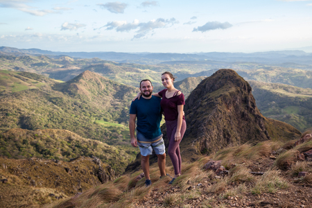Young couple enjoying the spectacular views of Guanacaste Costa Rica from the top of this local treasure, Cerro Pelado at sunsetの写真素材