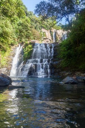 Nauyaca waterfalls with a deep swimming hole and large rocks in the south pacific of Costa Rica, a popular hiking destination.の写真素材