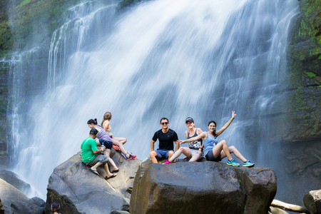 Nauyaca, Costa Rica - January 28: People sitting on the large boulders at the base of the falls. January 28 2018, Nauyaca, Costa Ricaのeditorial素材