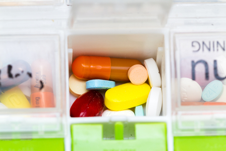 close up of an organizer for a daily regime of prescriptions drugsの写真素材