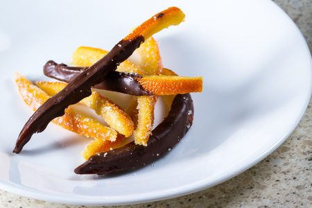 macro image of home made candied orange peel some pieces dipped in chocolateの写真素材