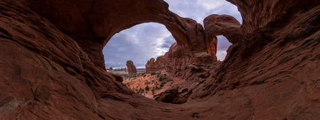 Double Arch from the inside looking out with a super wide angle perspective and random unrecognizable people in the frame to give size perspective of this amazing featureの写真素材