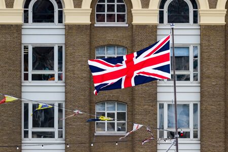Close up of the Union Jack Flag in London with old brick buildings in the Backgroundの写真素材