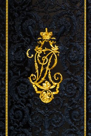 London  - September 06 2019: Close up of a gate with two cherubs placing a golden crown on a capital R in Buckingham Palace, London September 06,  2019のeditorial素材