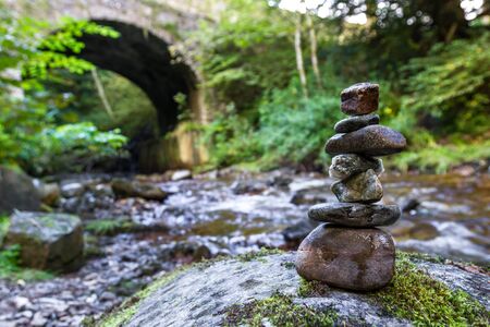 Stacked rocks at the Banvie burn near Pitlochry in the Scottish Highlands as the fresh water water runs downstream over the moss covered rocksの写真素材