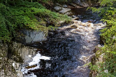 Brown waters running in the Scottish Highlands as a product of the peat moss in the Highlandsの写真素材