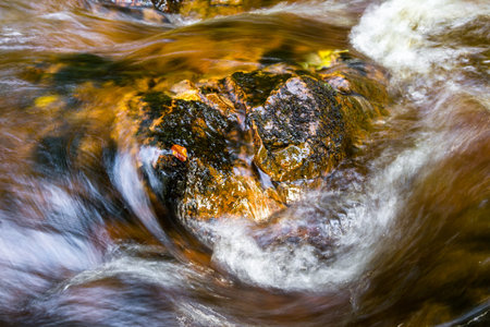 shallow burn flowing with fresh water with a reddish brown color characteristic of the Scottish...