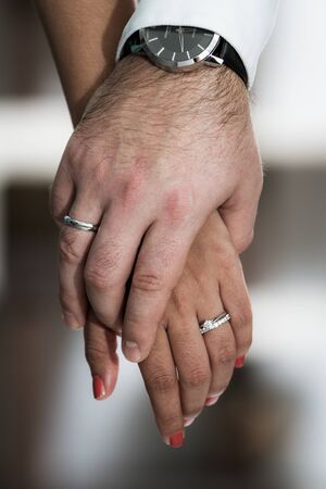 close up of the hands of a couple wearing their wedding bandsの写真素材