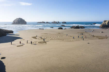 Bandon by the Sea, Oregon / USA - February 20 2020: The team of Circles in the Sand drawing a walkable labyrinth in the flat sandy beach of Face Rock State Parkのeditorial素材