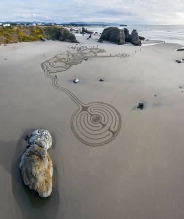 Bandon by the Sea, Oregon / USA - March 08 2020: Team of Circles in the Sand drawing a walkable labyrinth on the beach of Face Rock State Parkのeditorial素材
