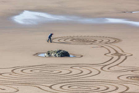 Bandon by the Sea, Oregon / USA - February 20 2020: The team of Circles in the Sand drawing a walkable labyrinth in the flat sandy beach of Face Rock State Parkのeditorial素材