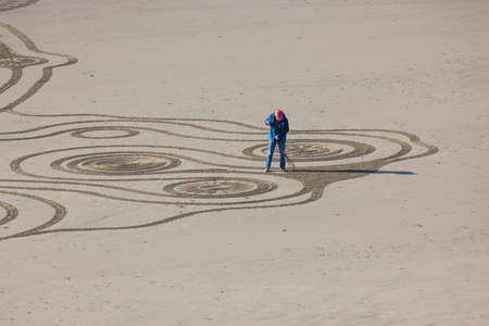 Bandon by the Sea, Oregon / USA - February 20 2020: The team of Circles in the Sand drawing a walkable labyrinth in the flat sandy beach of Face Rock State Parkのeditorial素材