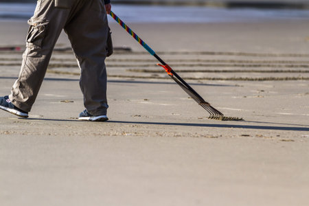 Bandon by the Sea, Oregon / USA - February 21 2020: close up of the team of Circles in the Sand drawing a walkable labyrinth in the flat sandy beach of Face Rock State Parkのeditorial素材