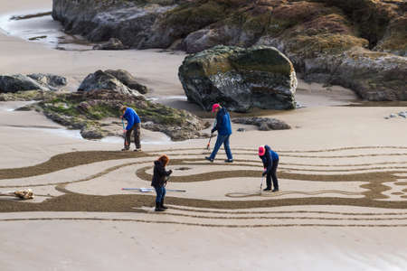 Bandon by the Sea, Oregon / USA - February 21 2020: The team of Circles in the Sand drawing a walkable labyrinth in the flat sandy beach of Face Rock State Parkのeditorial素材