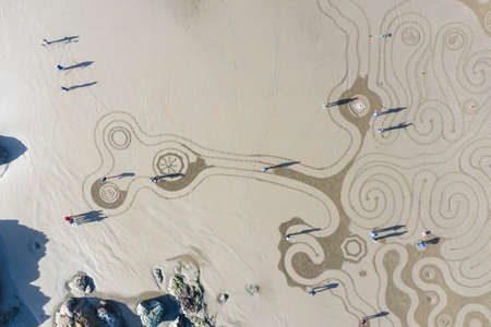 Bandon by the Sea, Oregon / USA - March 07 2020: The team of Circles in the Sand drawing a walkable labyrinth in the flat sandy beach of Face Rock State Parkのeditorial素材