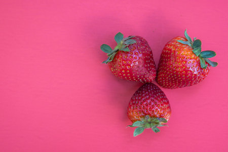Fresh ripe juicy strawberries isolated on a red background