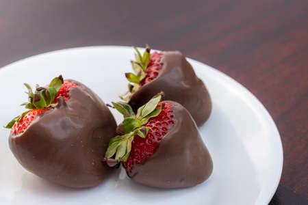chocolate covered strawberries on a white plateの写真素材