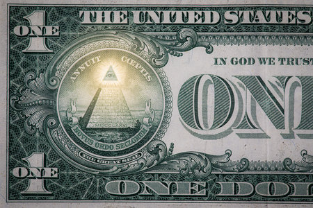 Close up of a small section of a one dollar bill showing the all seeing eye and the pyramid with a...