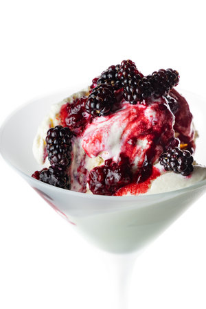 Fresh wild berries on top of vanilla ice cream isolated on a white background.の写真素材
