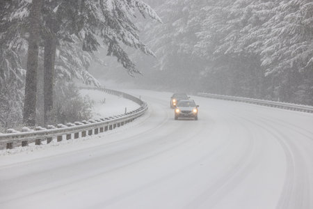 Passenger vehicles driving on snow covered highway 101 in Southern Oregon, February 2023の写真素材