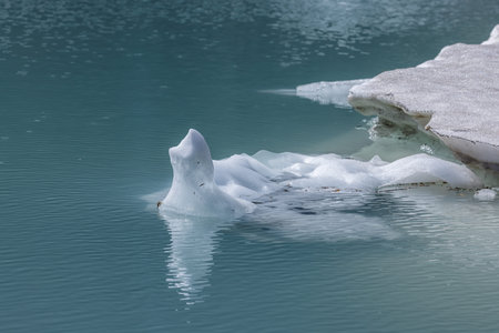 Icebergs floating in Upper Grinnell Lake in Glacier National Park montana on a beautiful afternoon.