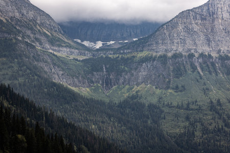 Beautiful and dramatic landscape of the mountains with fog and low clouds in Glacier Montana