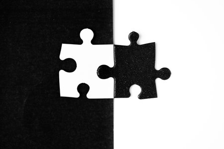 Opposite day concept using white and black puzzle pieces with oposite background color. Similar to a...