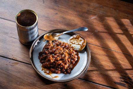 A can and a plate with beans on it ready to be devouredの写真素材