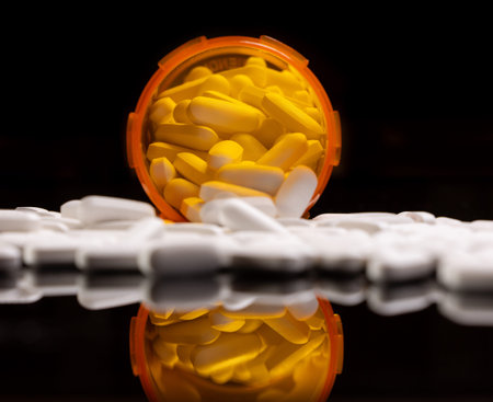 A visually dramatic shot showing a massive quantity of white pills spilling from an orange...