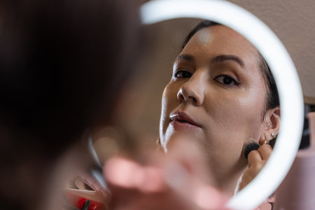 Personal and intimate moment of a beautiful, elegant woman applying makeup.の写真素材