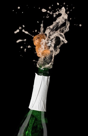 Champagne bottle with shooting cork, on black backgroundの写真素材