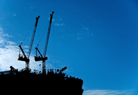 Silhouette of a tower crane that is building a building