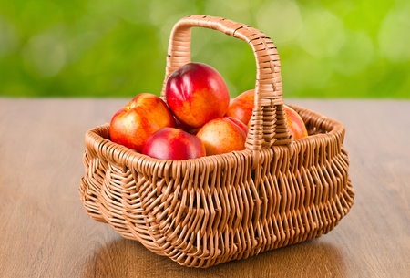 Fresh fruit nectarines in the basket with natural backgroundの写真素材