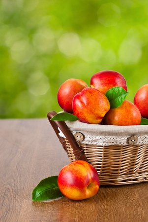 Fresh fruit nectarines in the basket with natural backgroundの写真素材