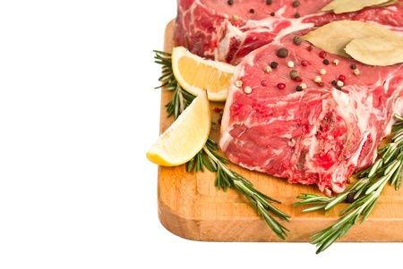 Raw meat with spices in wooden board, with copy space, isolated on white backgroundの写真素材
