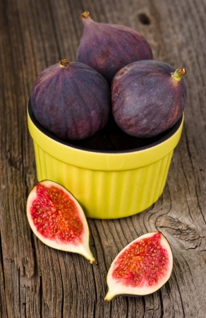 figs in a ceramic bowl on rustic wooden tableの写真素材
