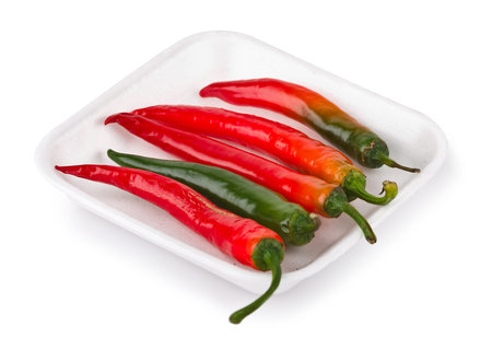 Hot red chilli peppers on market tray isolated on white background  with clipping path 