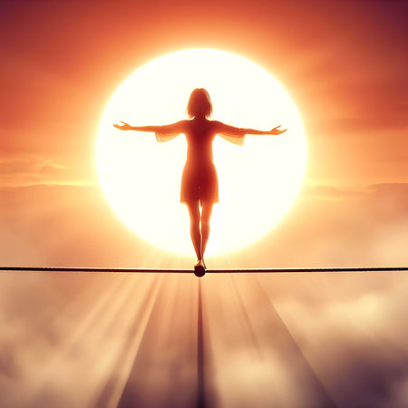 Silhouette of a woman balancing on a tightrope against a sunset skyの素材