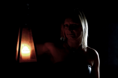 young blond girl in the dark with a lanternの写真素材