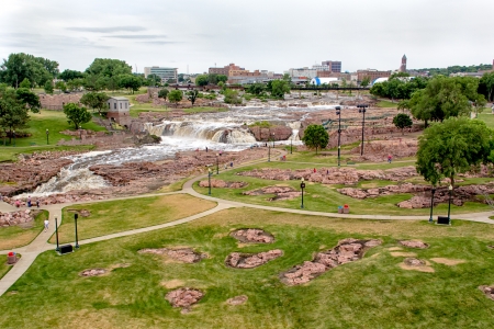 Raging Water of the Big Sioux River at Falls Park and Sioux Falls Skylineの写真素材
