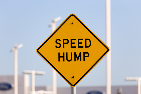 Speed hump sign on busy street.の写真素材