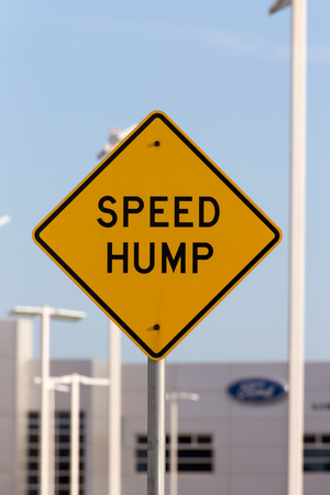 Speed hump sign on busy street.の写真素材